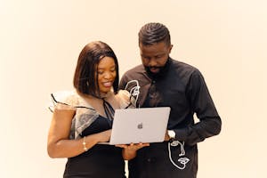 Man and woman collaborating on a laptop in a Lagos office setting.